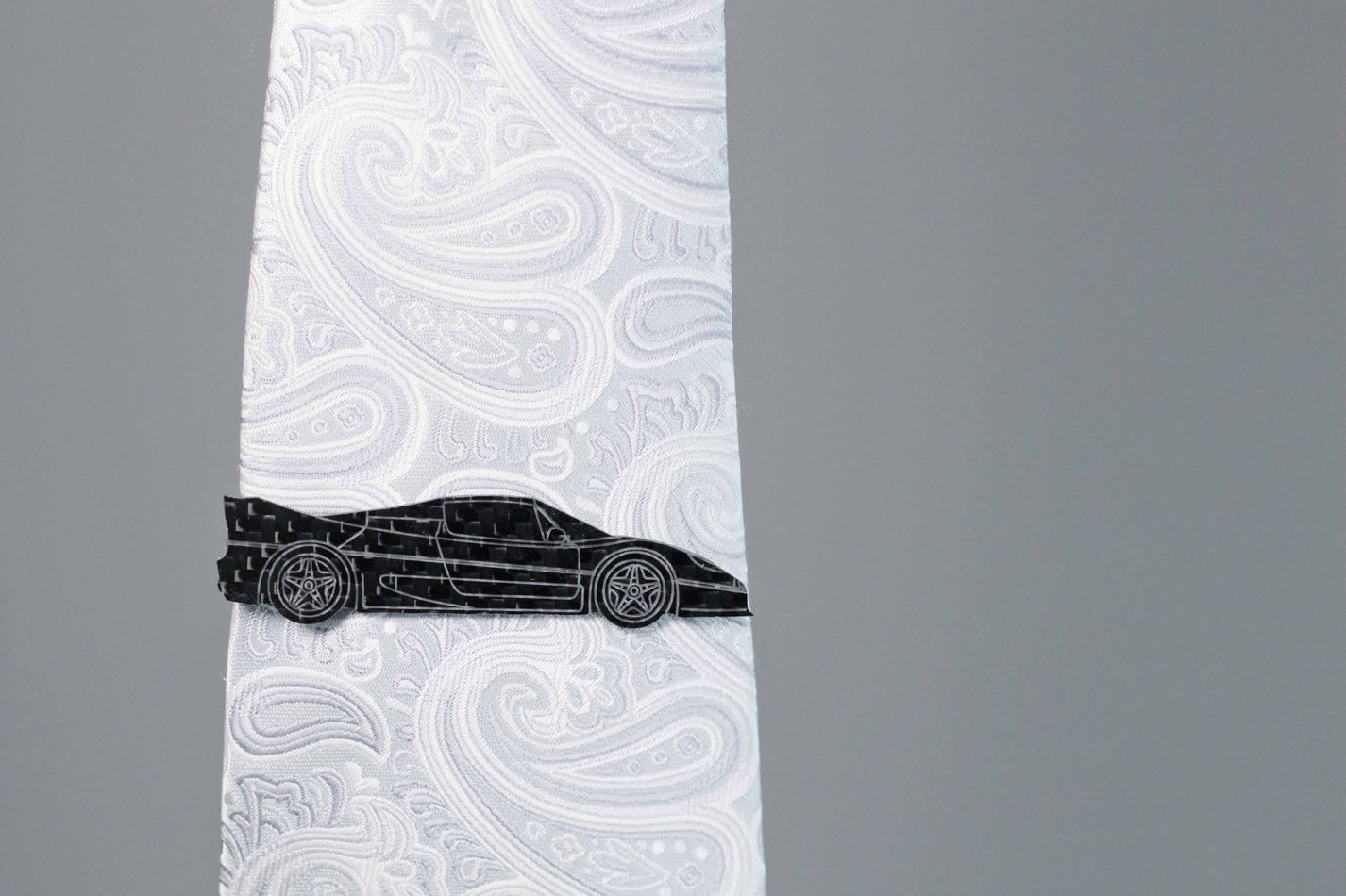 F50 carbon fiber tie clip on a silver tie. Perfect for any car lover.