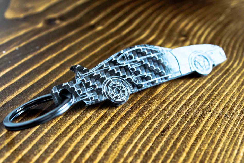 An MK4 Supra carbon fiber keychain, angle view