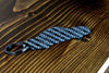 An SL65 Black Series carbon fiber keychain, angle view
