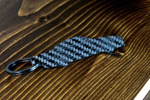 An SL65 Black Series carbon fiber keychain, angle view