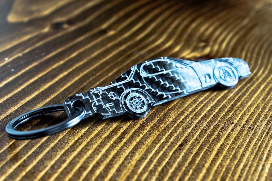 An FD RX-7 carbon fiber keychain, angle view